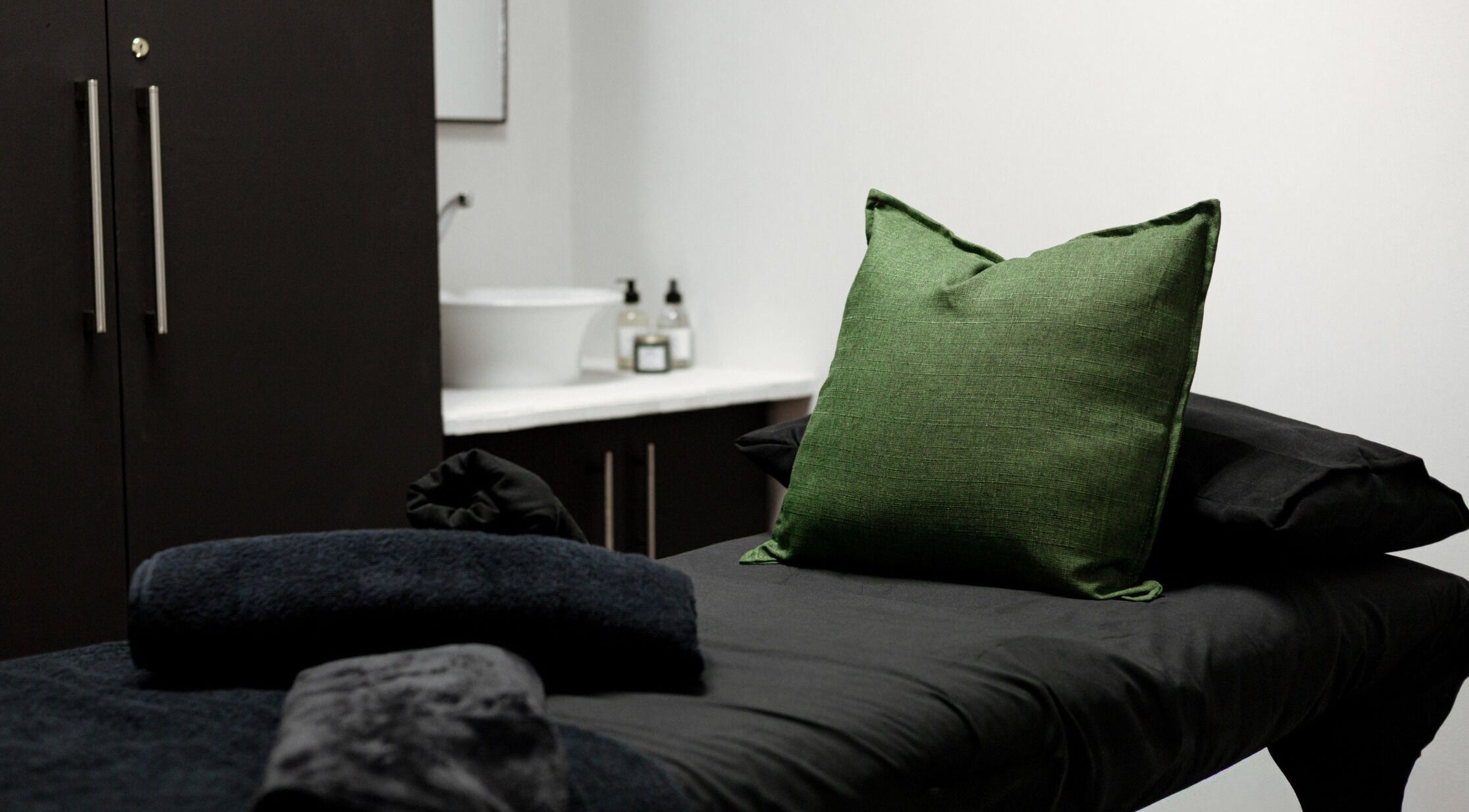 Spa treatment room at Tess Aesthetics in Johannesburg, Gauteng, ZA with a green pillow on a massage table.