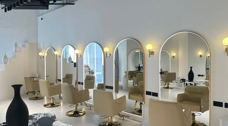 Interior moderno de Elías Guerrero Beauty Salon en Dubái, Dubái, AE con sillas de lujo y espejos iluminados.