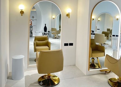 Interior elegante de Elías Guerrero Beauty Salon, Dubái, Dubái, AE con sillas frente a espejos iluminados.