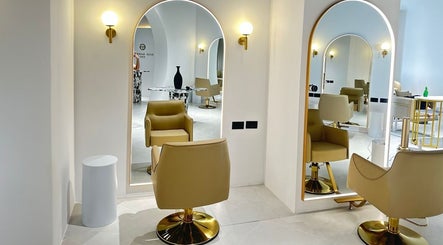 Interior elegante de Elías Guerrero Beauty Salon, Dubái, Dubái, AE con sillas frente a espejos iluminados.