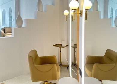 Zona de asientos elegantes en Elías Guerrero Beauty Salon, Dubái, Dubái, AE con sillones modernos.