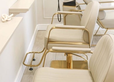 Luxury hair salon chairs at Gemma Mason Hair, Stockport, England, GB. Sleek design with beige and gold accents.
