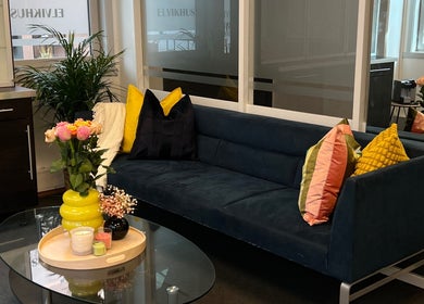 Inviting seating area at Maniq in Nesbru, Akershus, NO with a sleek sofa and vibrant decor.