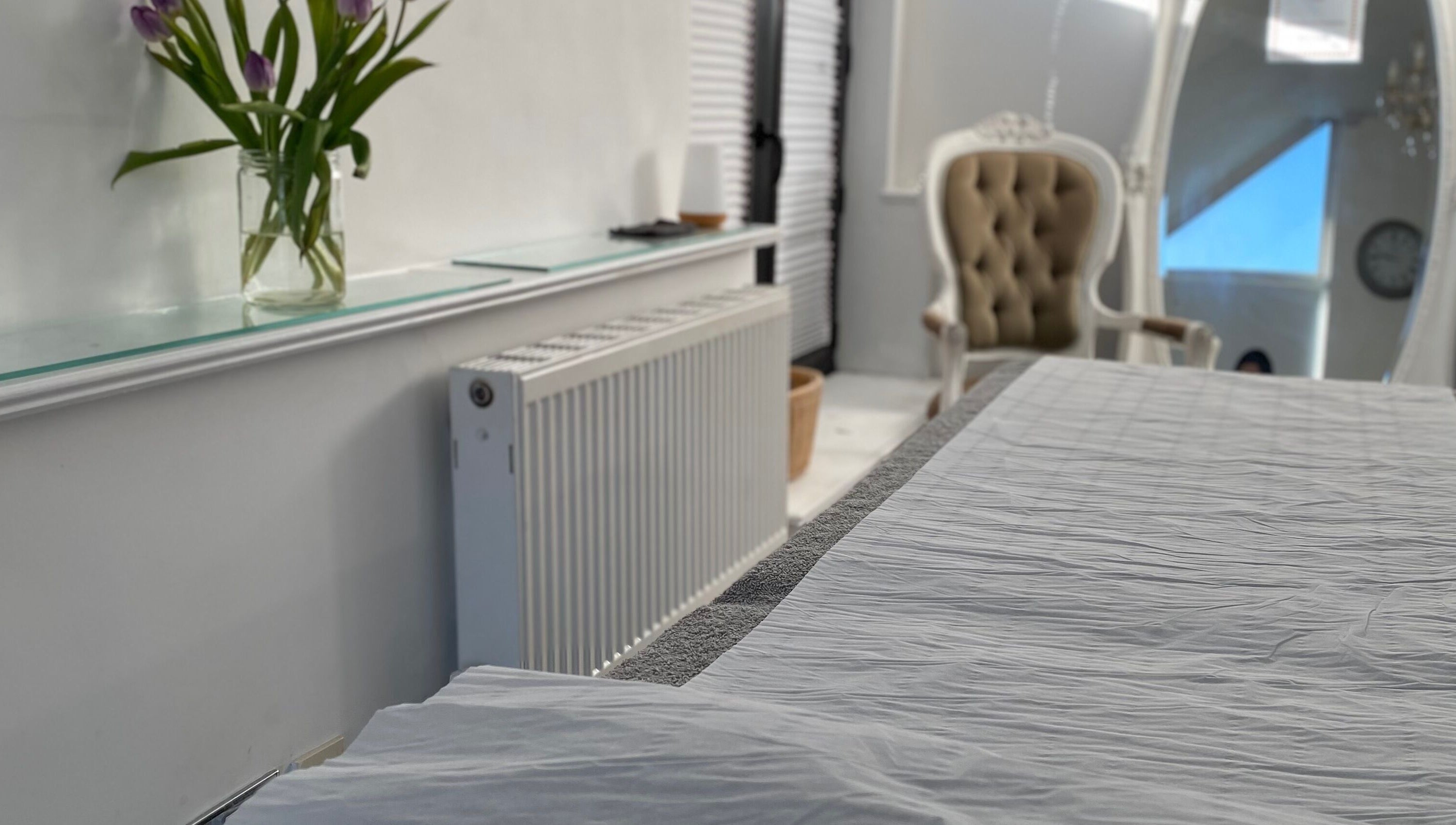 Elegant treatment room at Raha Aesthetics, Cardiff, Wales, GB, featuring a plush chair and calming ambiance.