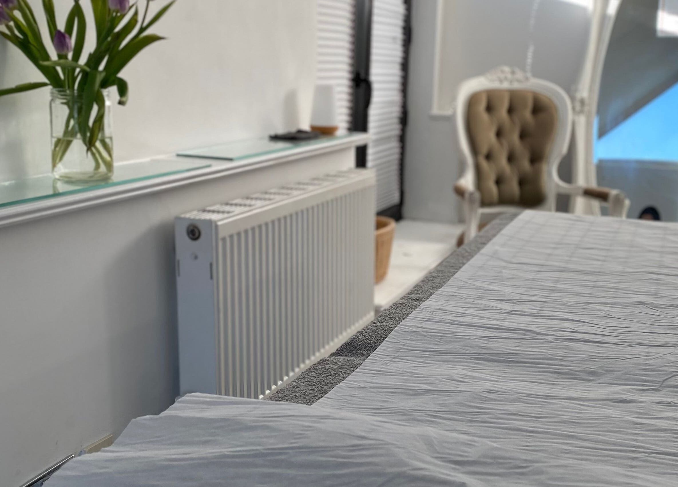 Elegant treatment room at Raha Aesthetics, Cardiff, Wales, GB, featuring a plush chair and calming ambiance.