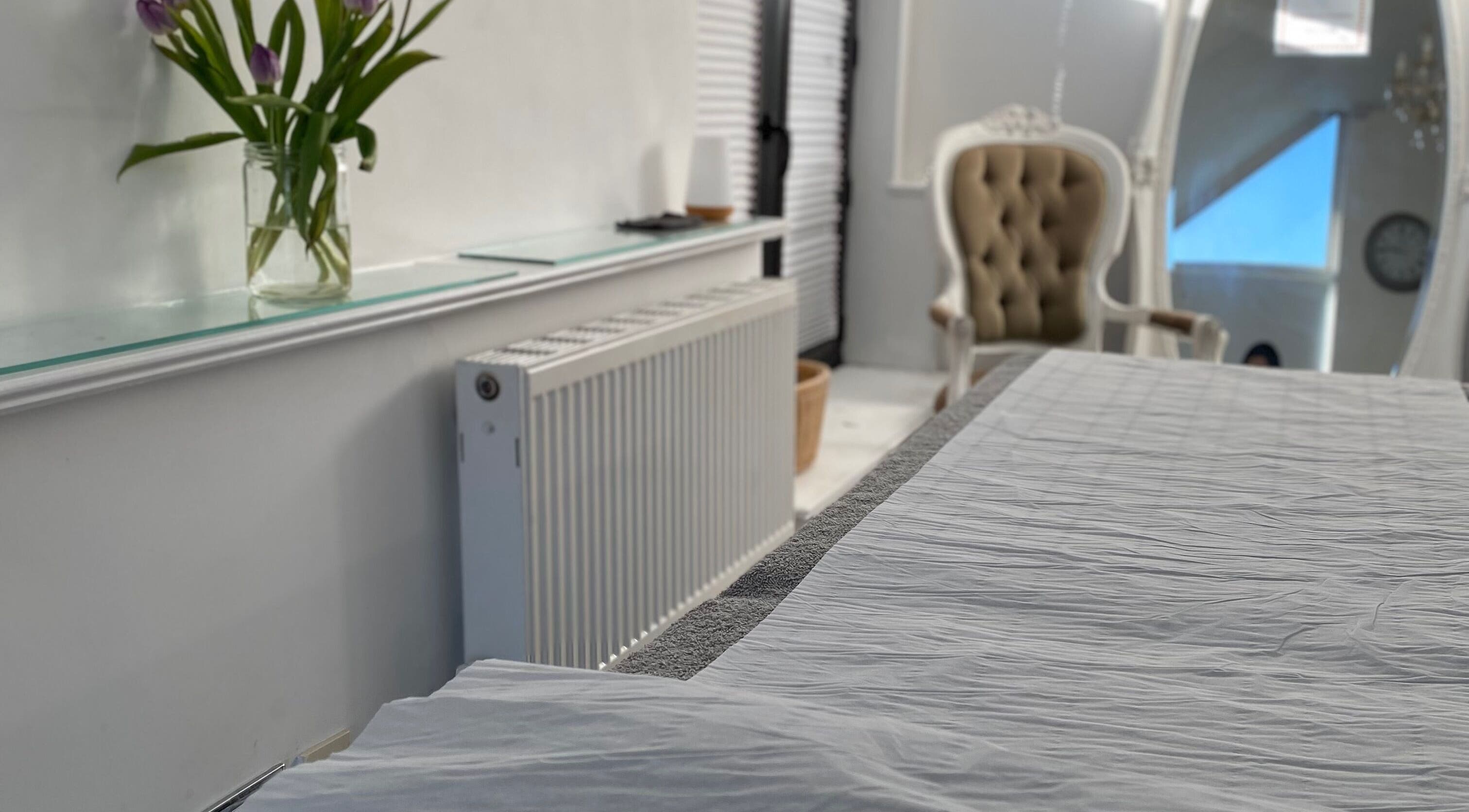 Elegant treatment room at Raha Aesthetics, Cardiff, Wales, GB, featuring a plush chair and calming ambiance.