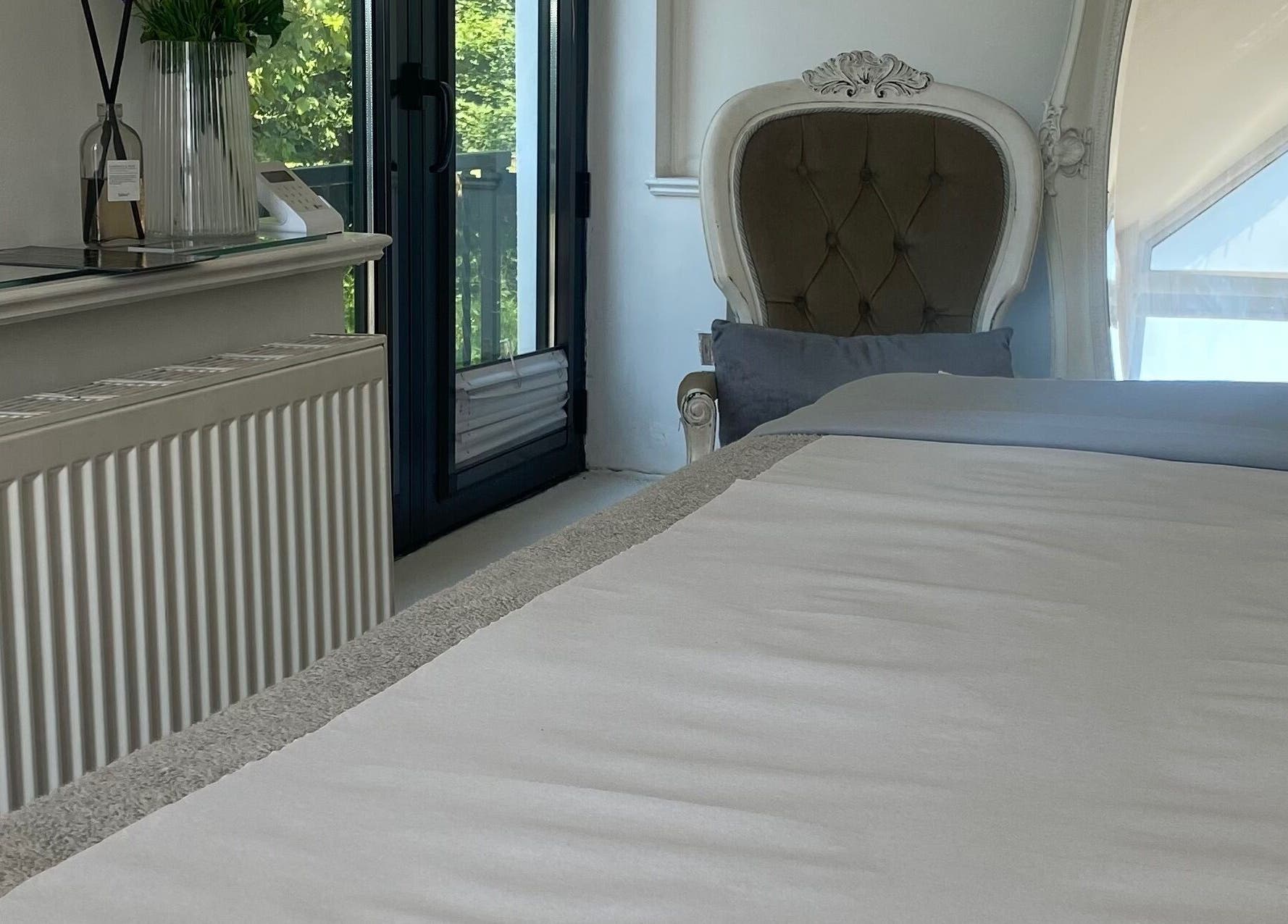 Luxurious treatment room at Raha Aesthetics, Cardiff, Wales, GB, featuring elegant decor and natural light.