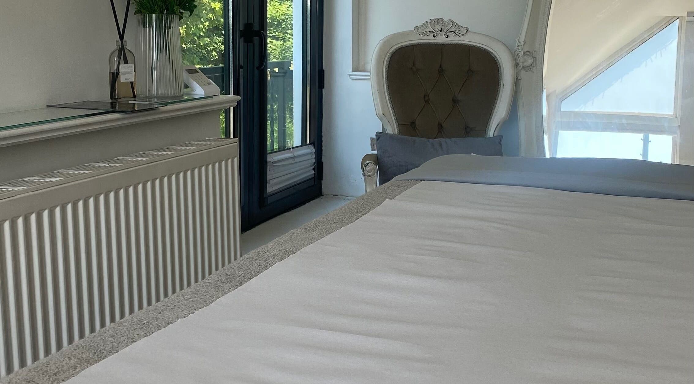 Luxurious treatment room at Raha Aesthetics, Cardiff, Wales, GB, featuring elegant decor and natural light.