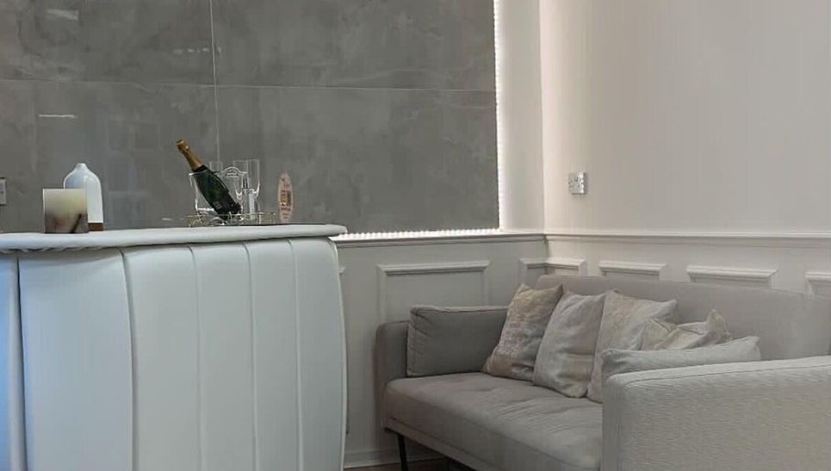 Elegant reception area at The Plump Project in Shirley, England, GB featuring cozy gray seating and a stylish bar.