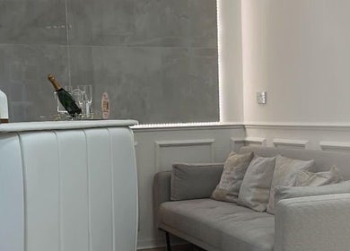 Elegant reception area at The Plump Project in Shirley, England, GB featuring cozy gray seating and a stylish bar.