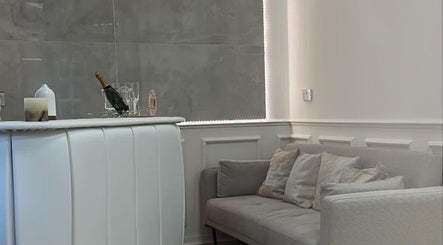 Elegant reception area at The Plump Project in Shirley, England, GB featuring cozy gray seating and a stylish bar.