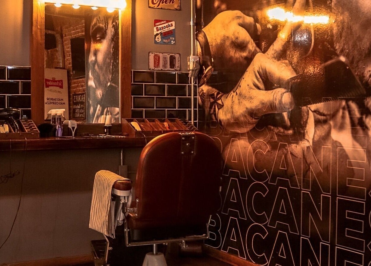 Sofisticado interior de Bacanes en San Juan, San Juan, AR con silla de barbería clásica iluminada.