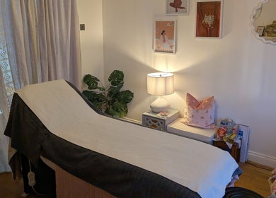 Luxury treatment room at Peach Beauty in London, England, GB, featuring a massage bed with elegant decor.