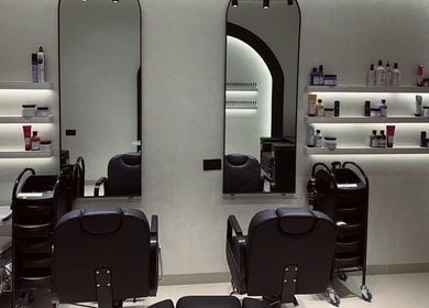 Interior of Velvet Rose Women Salon, Dubai, featuring sleek styling stations and beauty products on shelves.