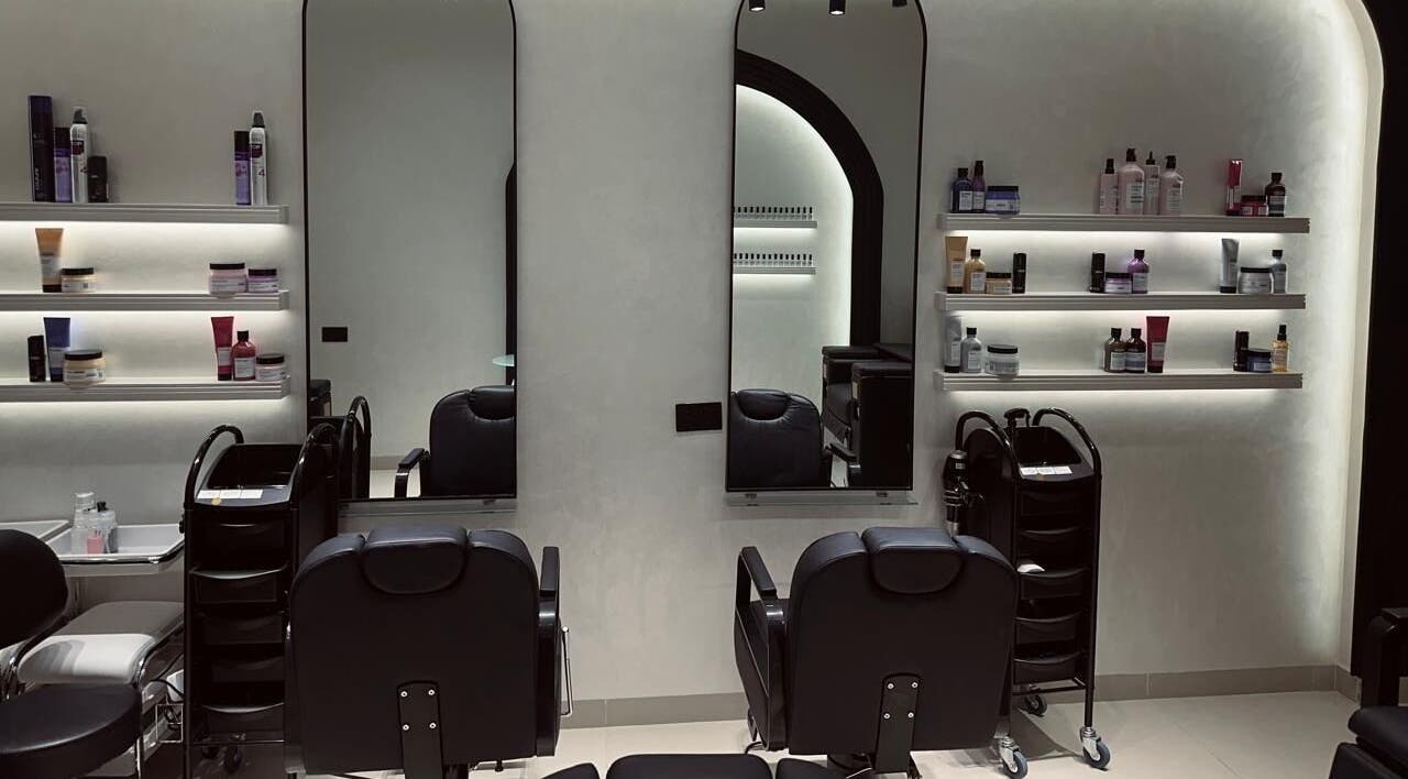 Interior of Velvet Rose Women Salon, Dubai, featuring sleek styling stations and beauty products on shelves.