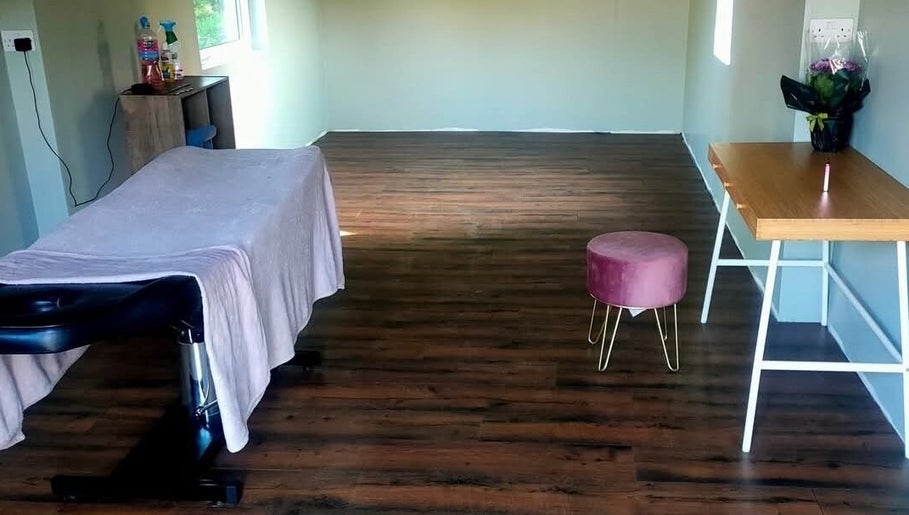 Relaxing massage room at Recovery Massage Therapy, Omagh, Northern Ireland, GB with a massage table and stool.
