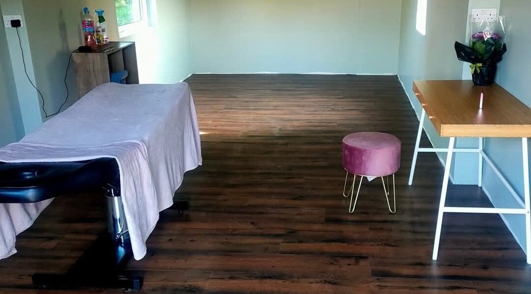 Relaxing massage room at Recovery Massage Therapy, Omagh, Northern Ireland, GB with a massage table and stool.