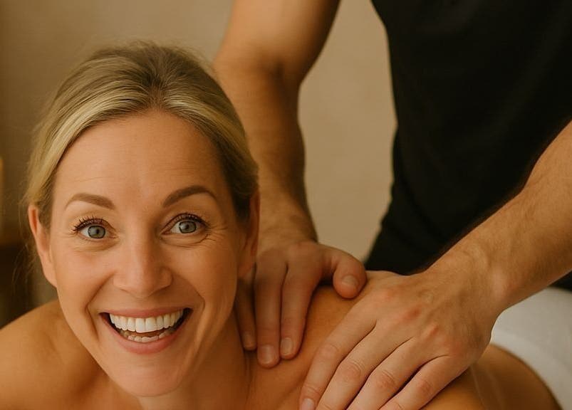 Smiling woman receiving a massage at Benji, Brossard, Québec, CA with candle ambiance.