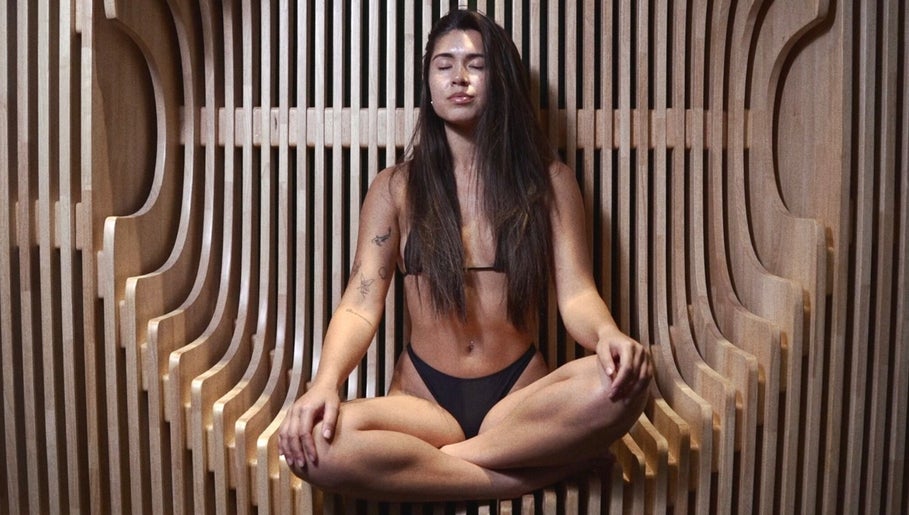 Woman meditating in stylish wood spa at Bioshack, British Columbia, British Columbia, CA.