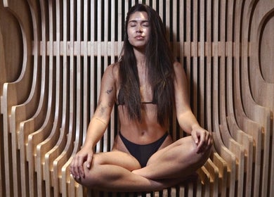Woman meditating in stylish wood spa at Bioshack, British Columbia, British Columbia, CA.