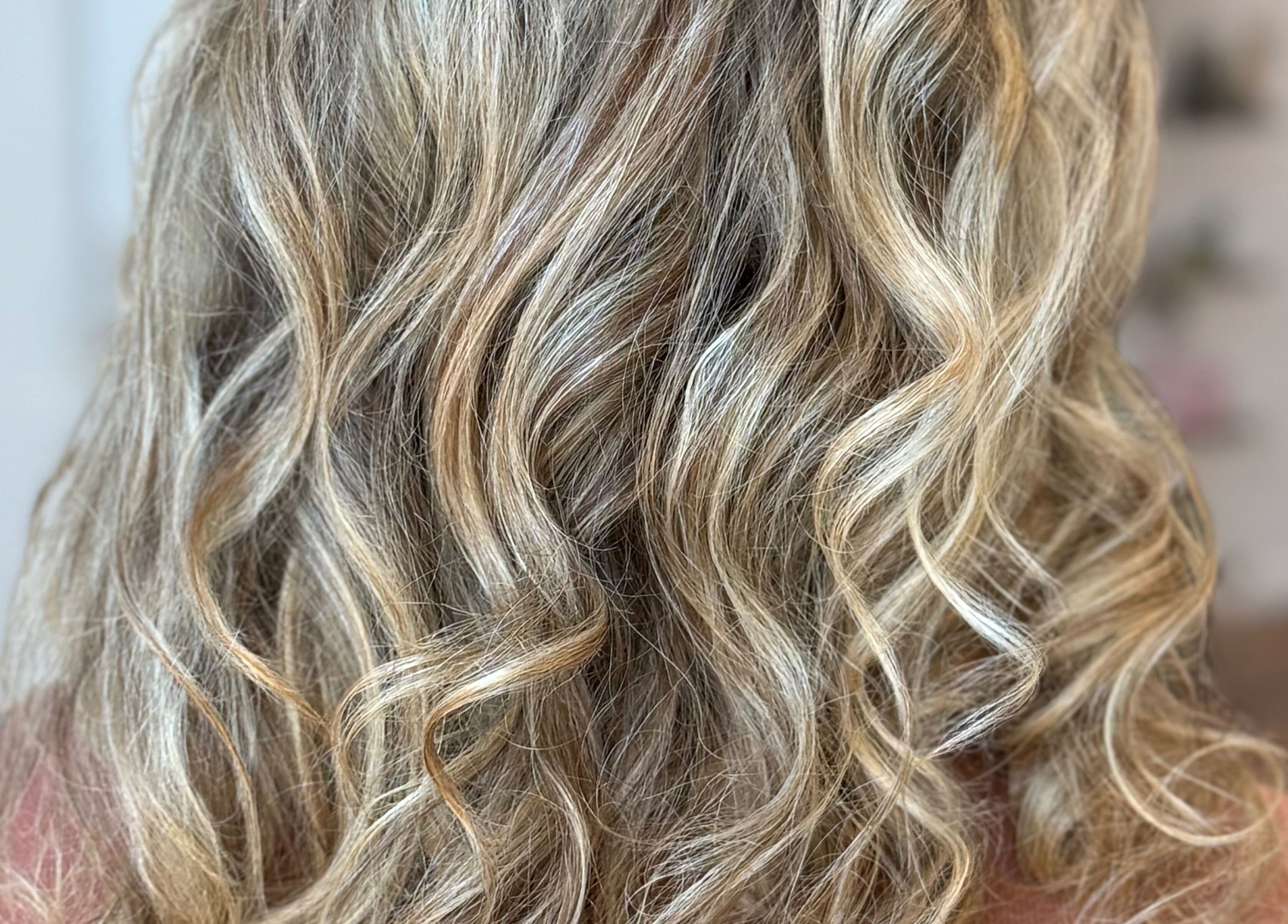 Back view of wavy, blonde hairstyle at Hair To A T By Tee, Arnoldsville, Georgia, US.