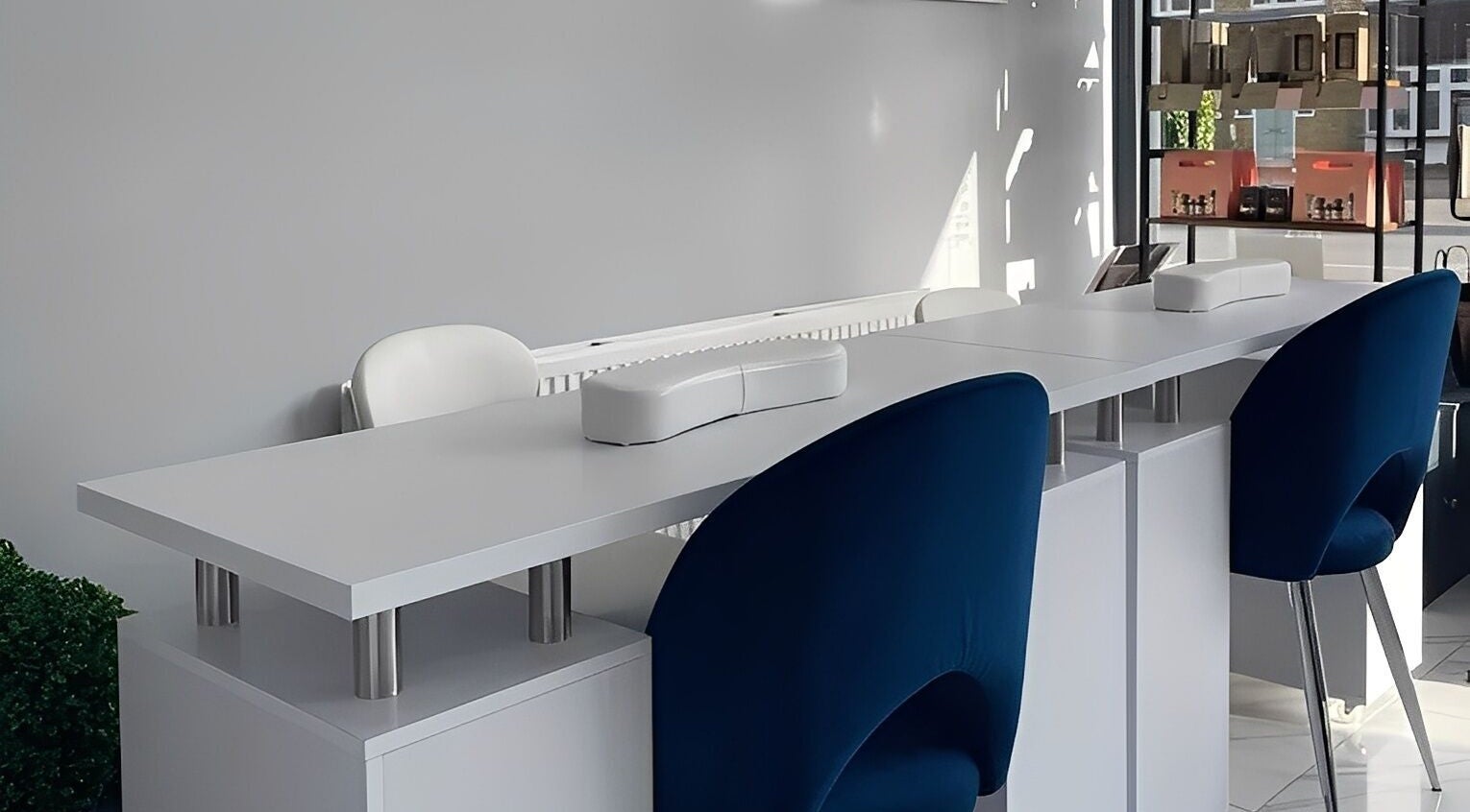 Modern manicure setup at Studio N in West Wickham, England, GB featuring sleek white tables and blue chairs.