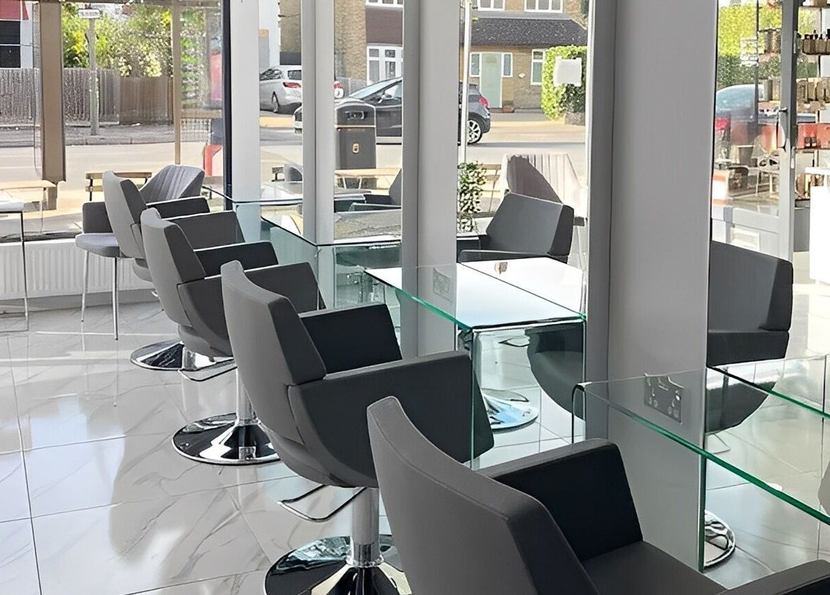 Modern salon interior at Studio N, West Wickham, England, GB with glass tables and stylish chairs.