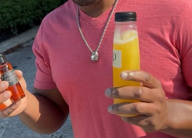 Man holding wellness oil and juice at Sacred Diamond Lifestyle Club, Nashville, Tennessee, US.