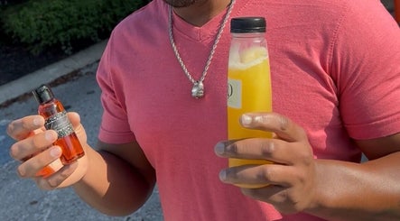 Man holding wellness oil and juice at Sacred Diamond Lifestyle Club, Nashville, Tennessee, US.