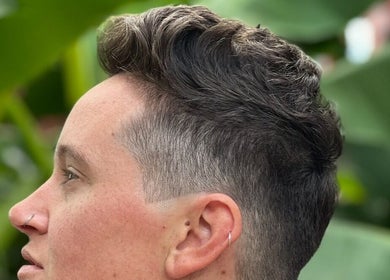 Stylish short haircut at Sacred Diamond Lifestyle Club in Nashville, Tennessee, US with lush greenery background.