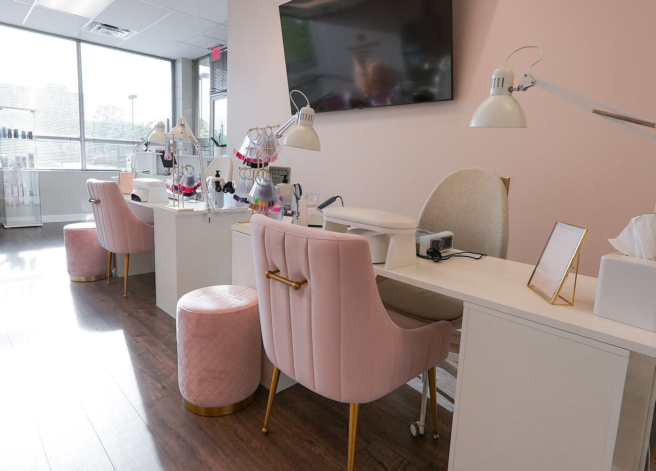 Elegant nail salon setup in Kvadrat Room, Des Plaines, Illinois, US with pink chairs and modern decor.