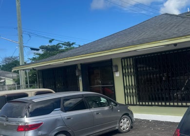 Exterior of Facial Expressions Artistry in Nassau, New Providence, BS, featuring parking area.