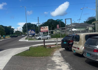 Street view near Facial Expressions Artistry in Nassau, New Providence, BS showing parked cars and signage.