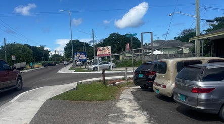 Street view near Facial Expressions Artistry in Nassau, New Providence, BS showing parked cars and signage.