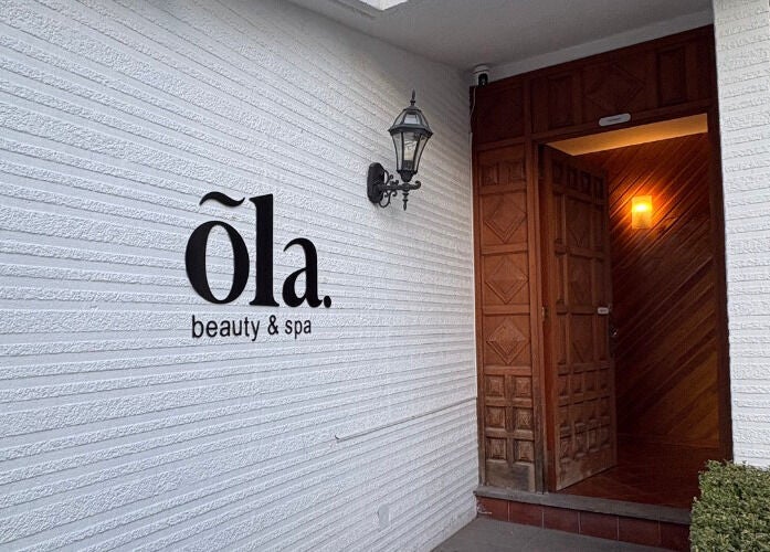 Fachada de Ola Beauty & Spa en Pachuca De Soto, Hidalgo, MX con puerta de madera y lámpara elegante.