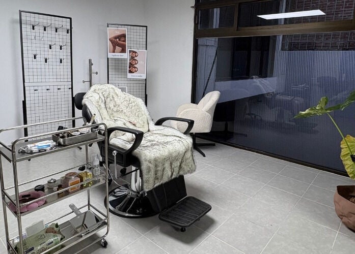 Sala de tratamiento en Ola Beauty & Spa, Pachuca De Soto, Hidalgo, MX con silla y planta decorativa.