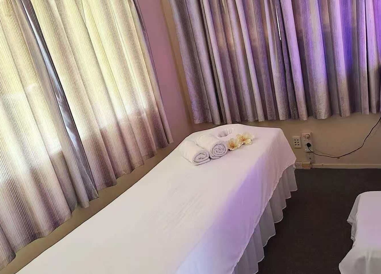 Relaxing massage room at Aah Spa Massage, Auckland, Auckland, NZ with soft lighting and a prepared massage table.