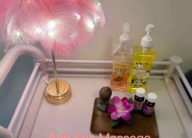 Relaxing spa table at Aah Spa Massage, Auckland, Auckland, NZ with pink feather lamp and massage oils.