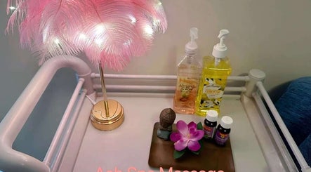 Relaxing spa table at Aah Spa Massage, Auckland, Auckland, NZ with pink feather lamp and massage oils.