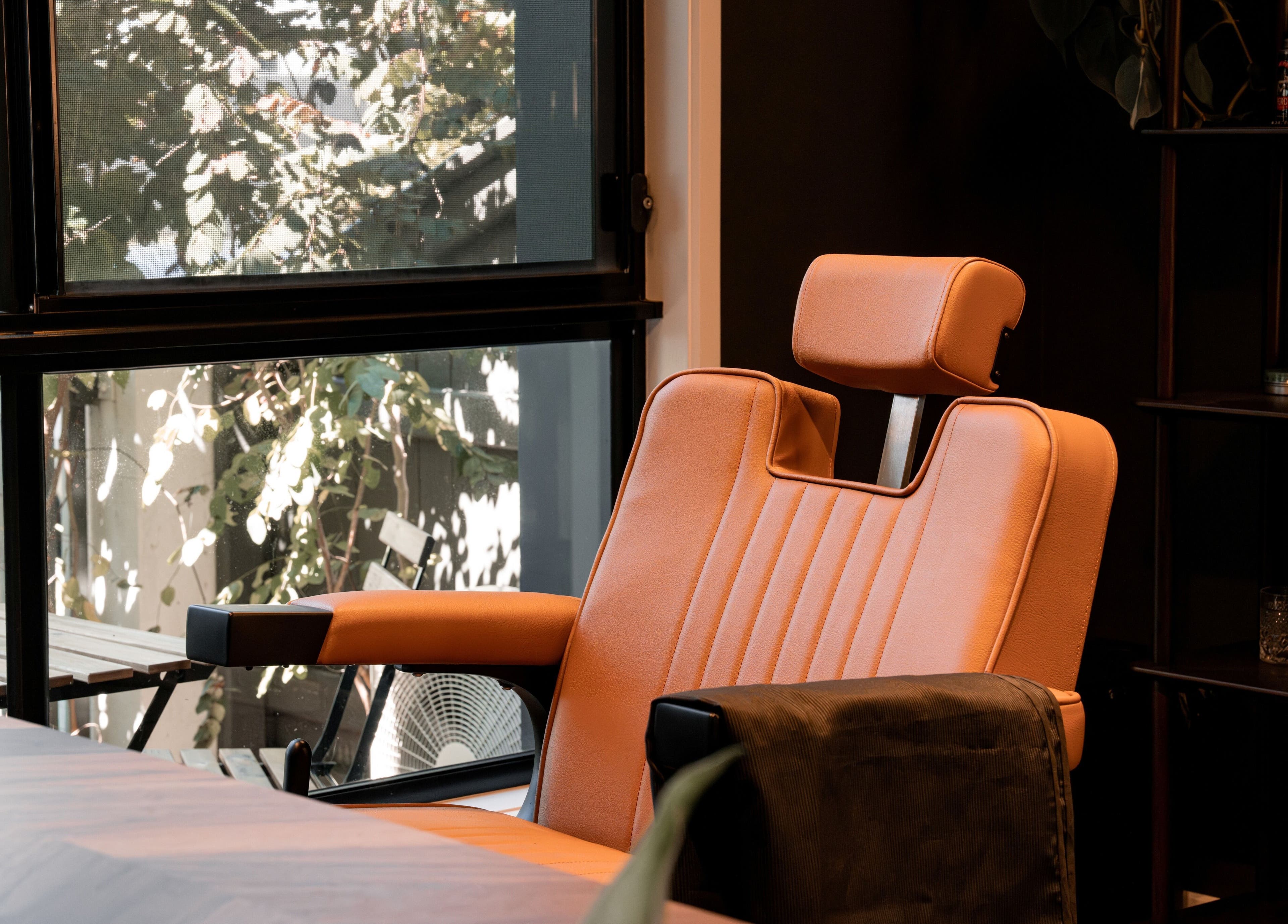 Comfortable barber chair at Caleb Sweeney Barber, Nirimba, Queensland, AU, by a sunlit window.