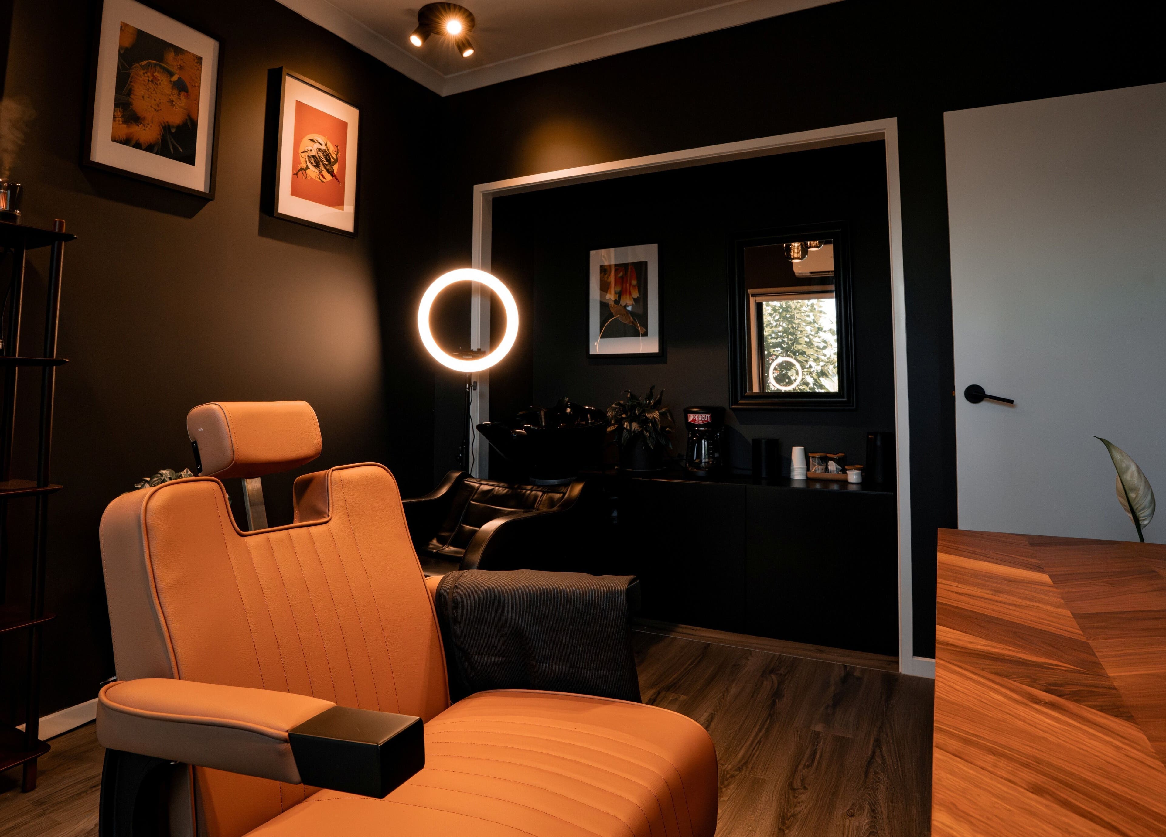 Cozy barber chair in Caleb Sweeney Barber's stylish space, Nirimba, Queensland, AU. Modern decor and warm lighting.