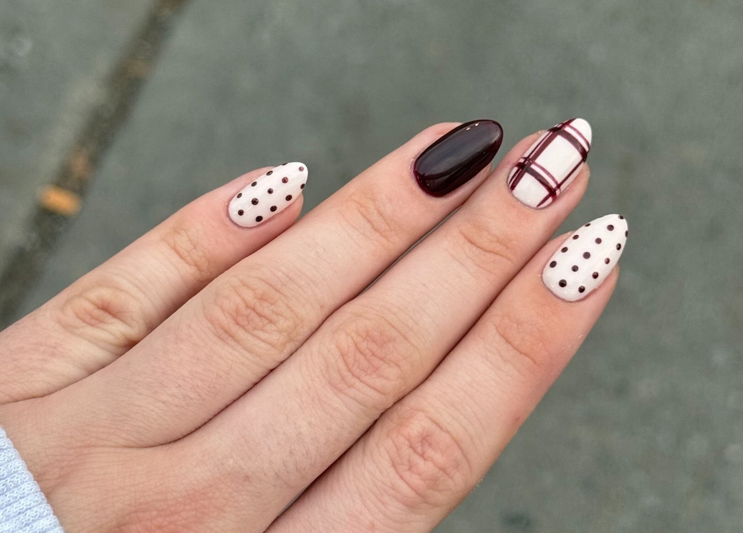 Design d'ongles élégant chez Nailsbypaulinemtl à Montréal, Québec, CA. Motifs bordeaux et pois sur fond neutre.