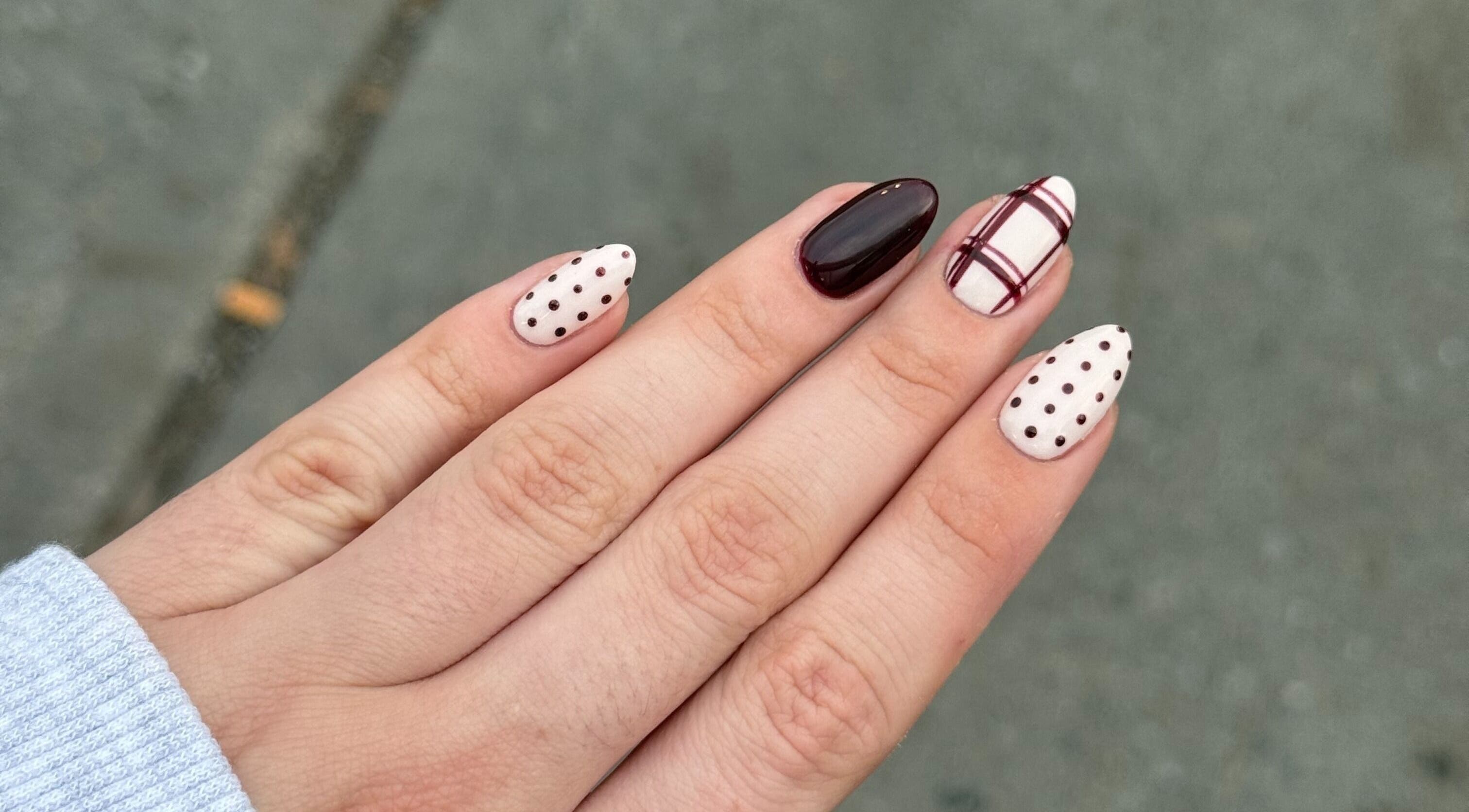 Design d'ongles élégant chez Nailsbypaulinemtl à Montréal, Québec, CA. Motifs bordeaux et pois sur fond neutre.