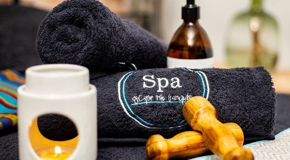 Spa essentials at Spa@primevenue, Lusaka, Lusaka Province, ZM, featuring towels, candle, and massage tool.