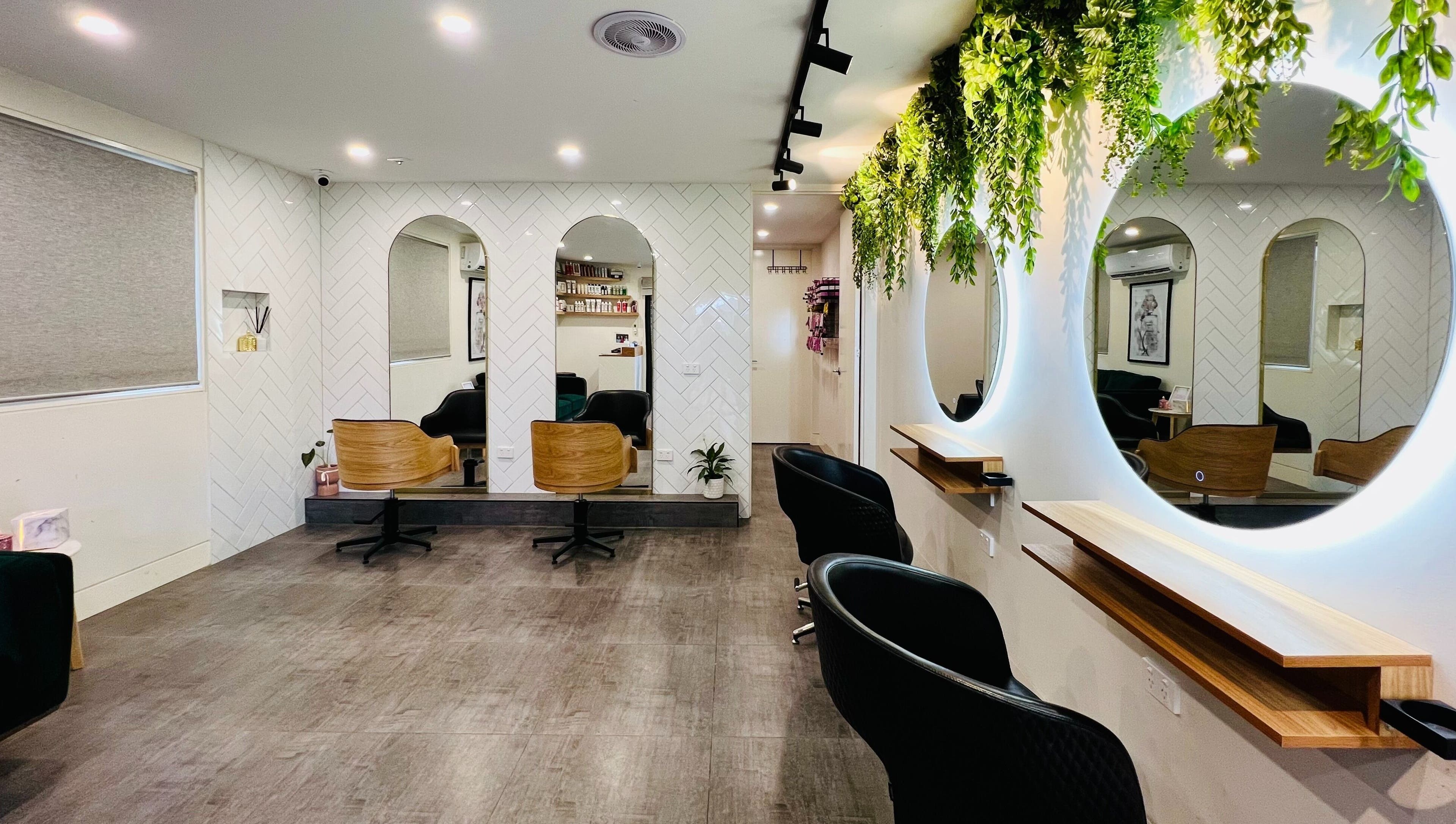 Elegant interior of Hairjaz Studio in Melbourne, Victoria, AU with stylish mirrors and lush greenery.