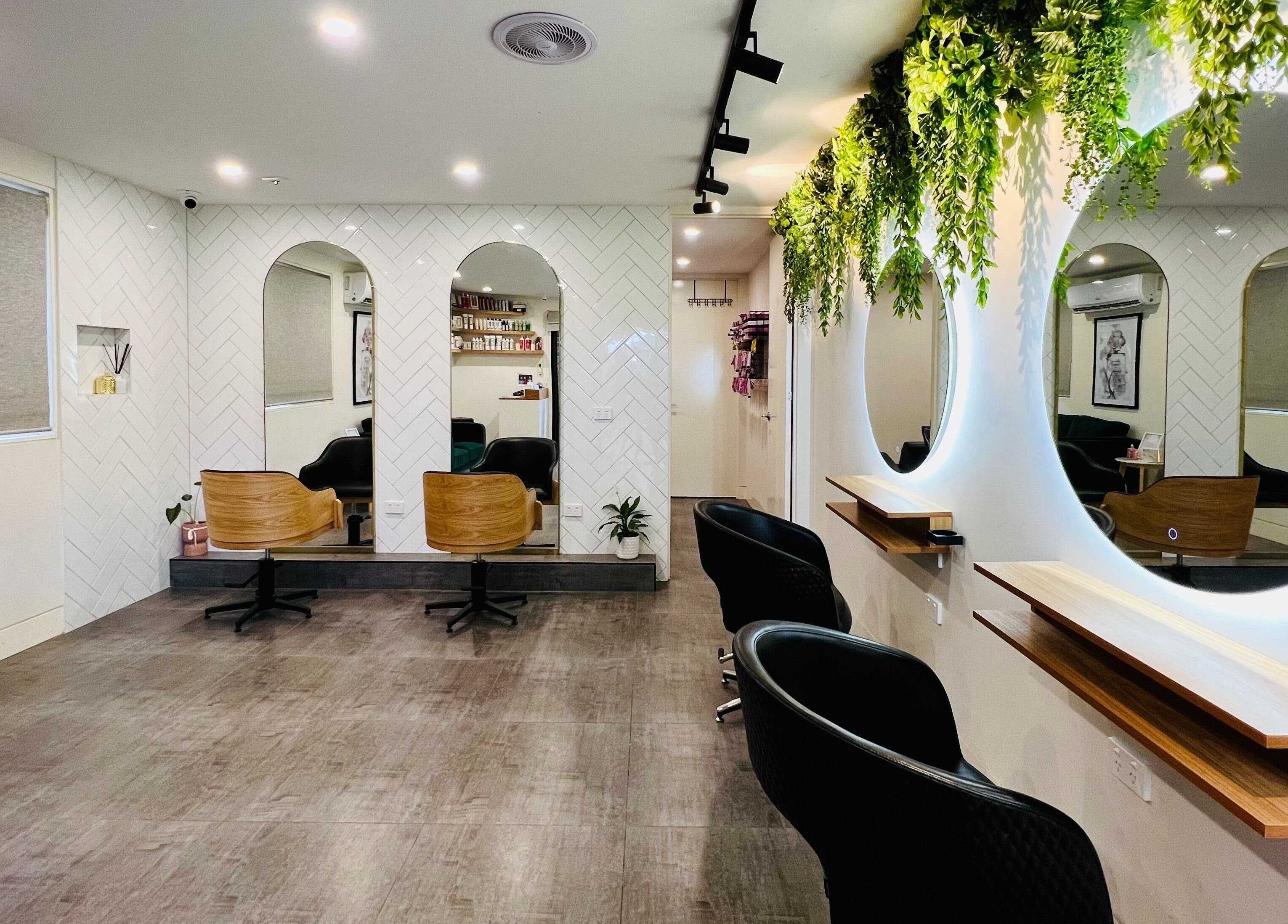 Elegant interior of Hairjaz Studio in Melbourne, Victoria, AU with stylish mirrors and lush greenery.