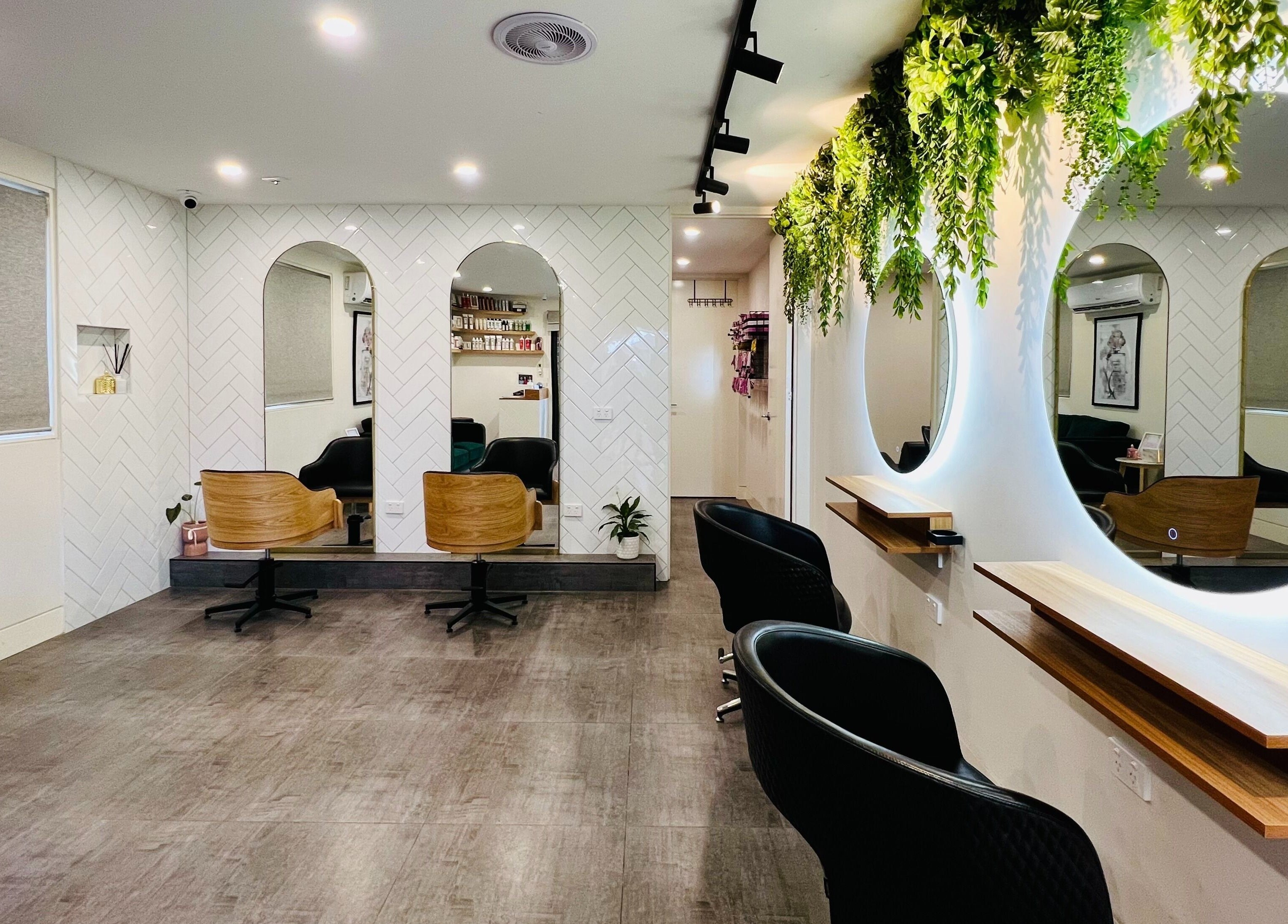 Elegant interior of Hairjaz Studio in Melbourne, Victoria, AU with stylish mirrors and lush greenery.