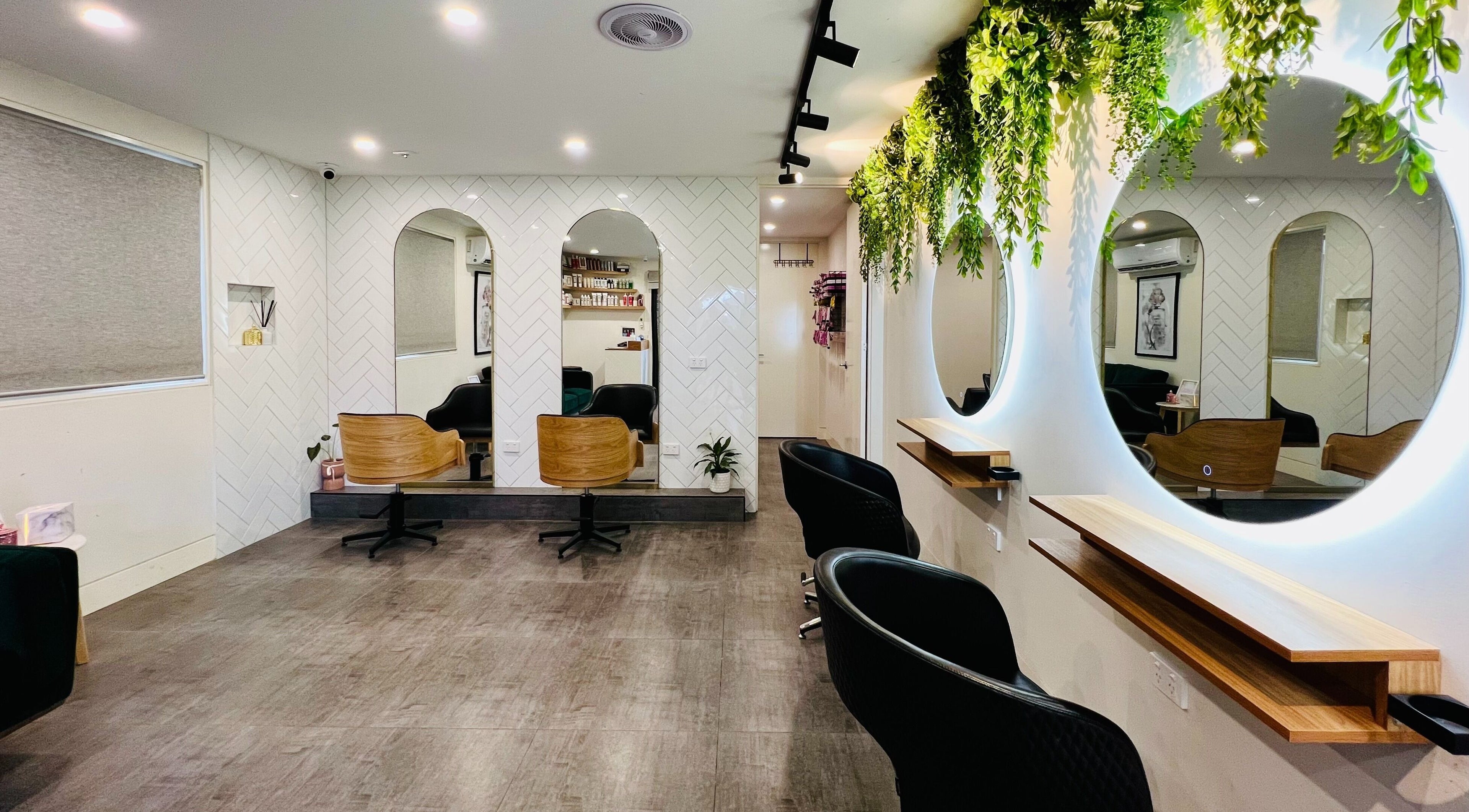 Elegant interior of Hairjaz Studio in Melbourne, Victoria, AU with stylish mirrors and lush greenery.