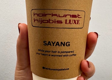 Hand holding coffee cup at Hairkunst Hijabis Luxe, Bandar Baru Bangi, Selangor, MY.