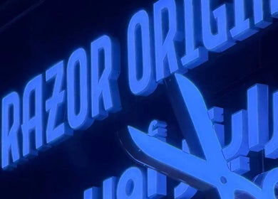 Illuminated Razor Origin Barbershop sign with scissors in Buqayq, Eastern Province, SA.